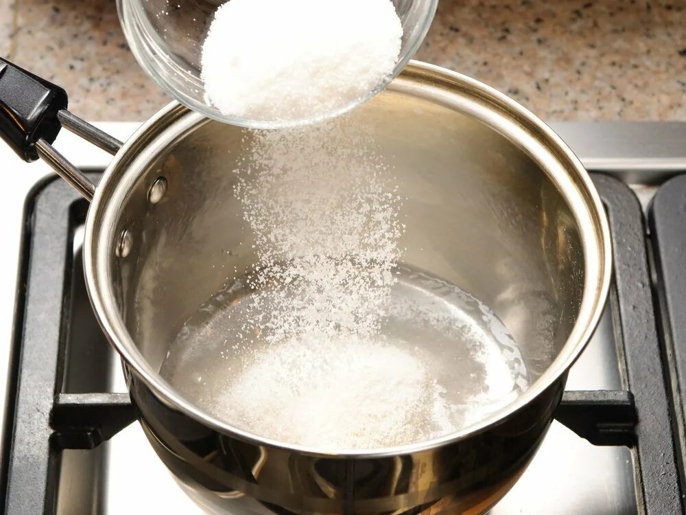 Вскипятить стакан воды. Сахар в кастрюле. Вода с сахаром в сотейнике. Насыпаем сахар в кастрюлю. Сахарный сироп в сотейнике.