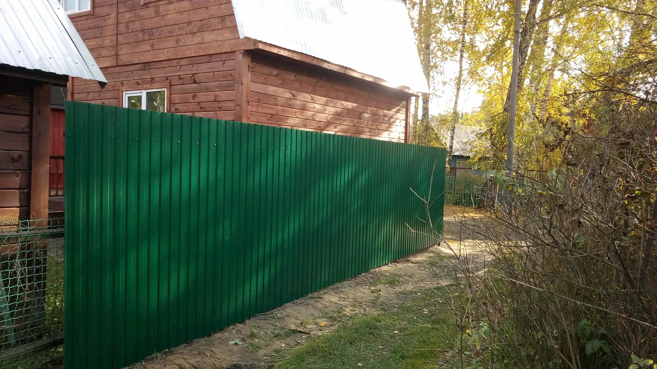 Забор из профлиста цены московская область. Профлист для забора. Зеленый забор из профнастила. Погнуло профлист морозным пучением. Ремонт заборов и построек на даче.