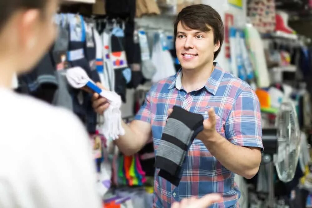 Мужчина выбирает одежду. Человек выбирает носки. Мужчина выбирает носки. Магазин носков.