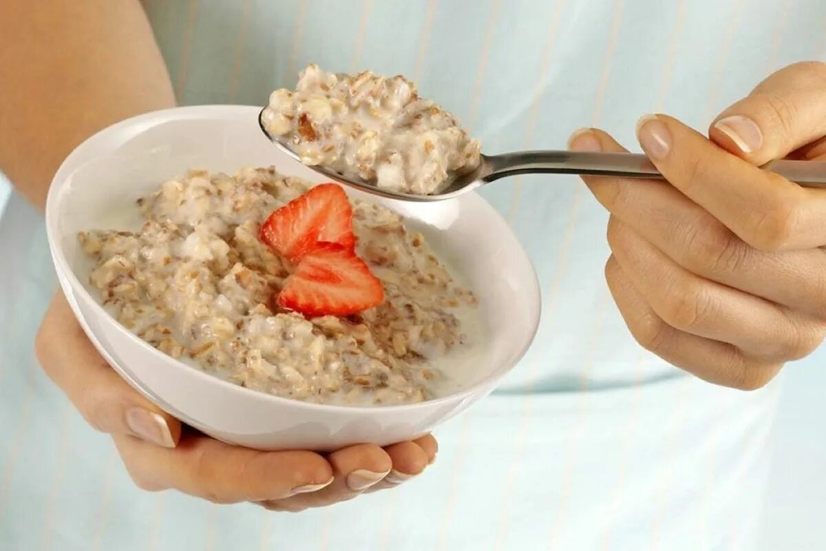 Овсяную кашу кушаю. Женщина ест кашу. женщина ест овсяную кашу. человек ест кашу. девушка ест овсянку.