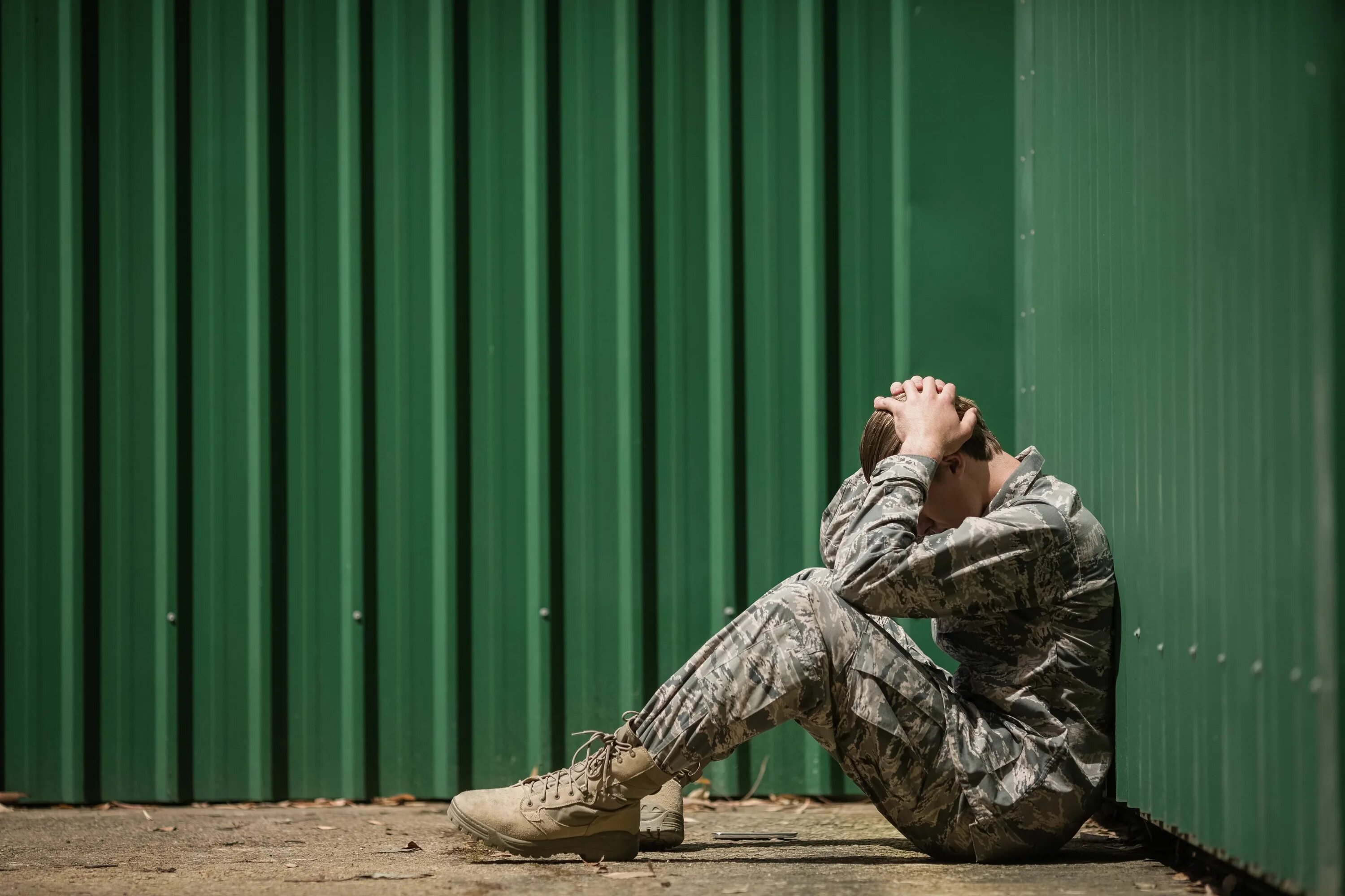 Грустный военный. Солдат сидит у стены. Военный сидит. Стресс военнослужащих. Военный стресс
