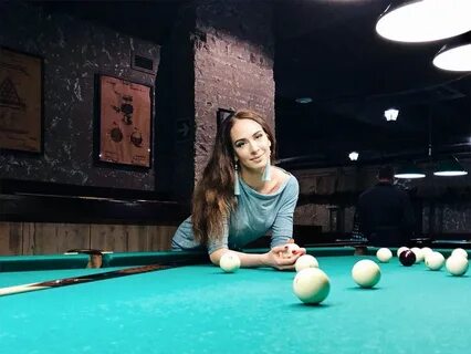 Девушка играет в бильярд