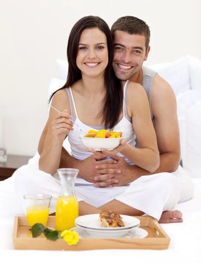 Пара завтракает в постели. Влюбленные вместе завтракают. Мужчина и женщина завтракают. Влюбленные завтракают в постели.