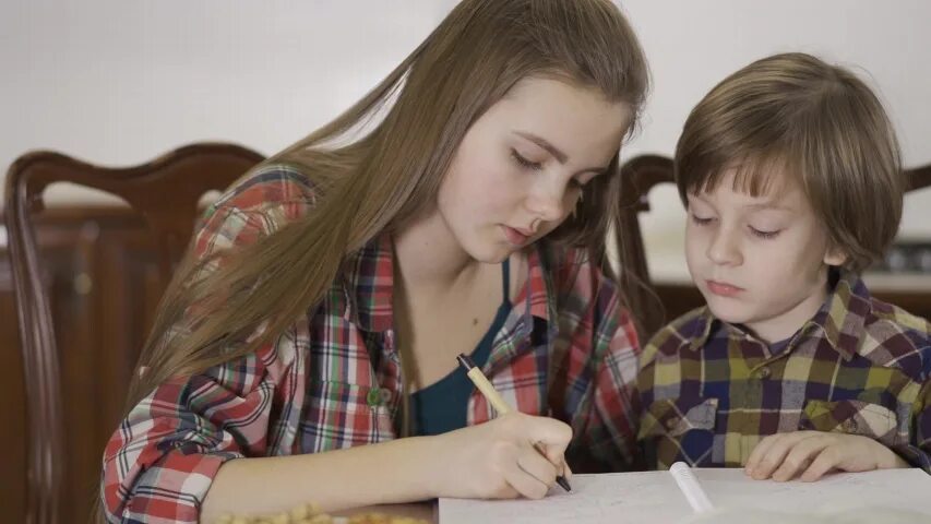 Older sister younger brother. Девочка делает с братом уроки. Девочка делает уроки с сестрой. Мальчик изучает девочку. Брат и сестра учат уроки.