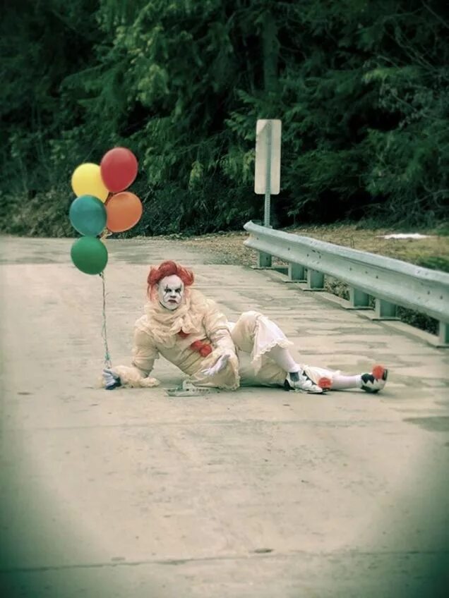 Клоун развлекающий в паузах между номерами. Клоуны на дорогах. Клоун с красным шариком.