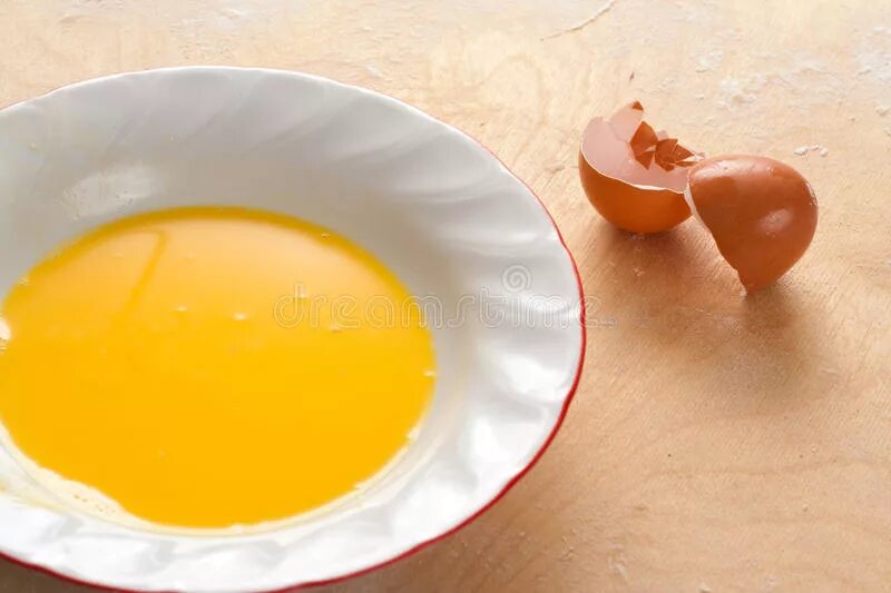 Яичная маска корейская. Оранжевые желтки и мука. Белый налет на желтке яйца. Желток яйца с оливковым маслом в чашке.