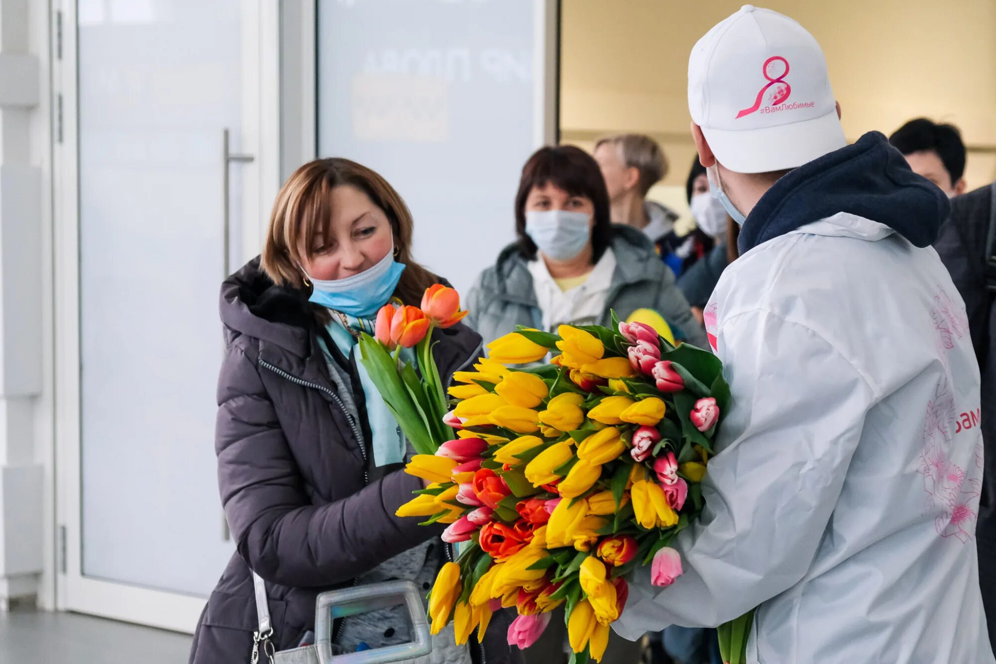Цветами встречала. Цветы в аэропорту. в аэропорту с цветами. встречает с цветами. волонтера цветок.
