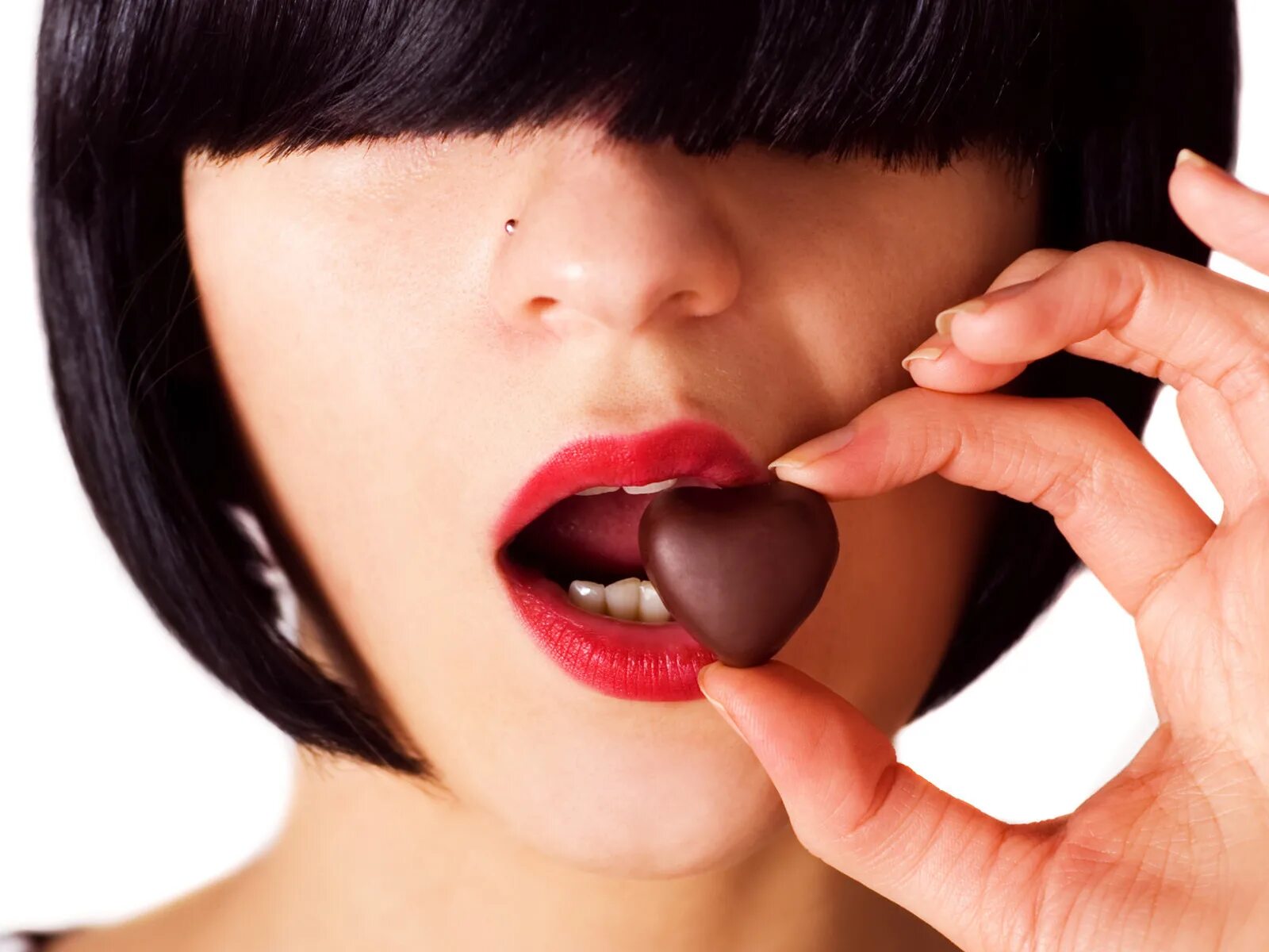 Есть шоколад на ночь. Девушка ест конфету. Девушка ест шоколадные конфеты. Женщина с конфетами. Шоколадные губы.