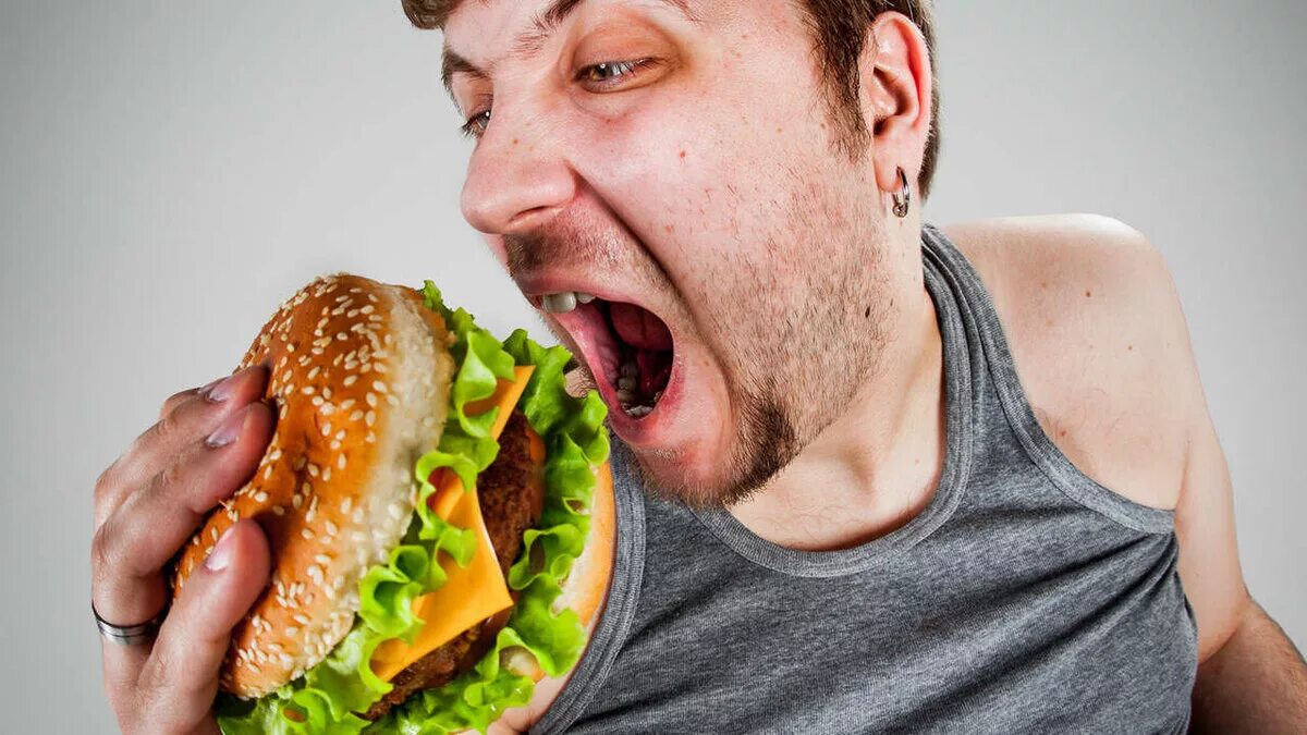 Жрет гамбургер. Человек ест. Человек ест гамбургер. Мужчина ест гамбургер.