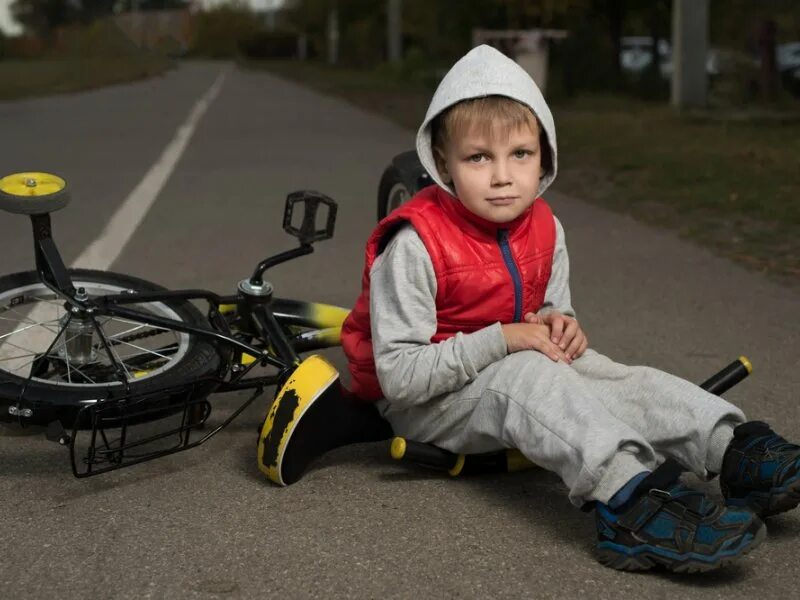 Fall off the bike. Мальчик упал с велосипеда. Ребенок упал с велосипеда. Мальчик на велосипеде. Грустный ребенок на велосипеде.