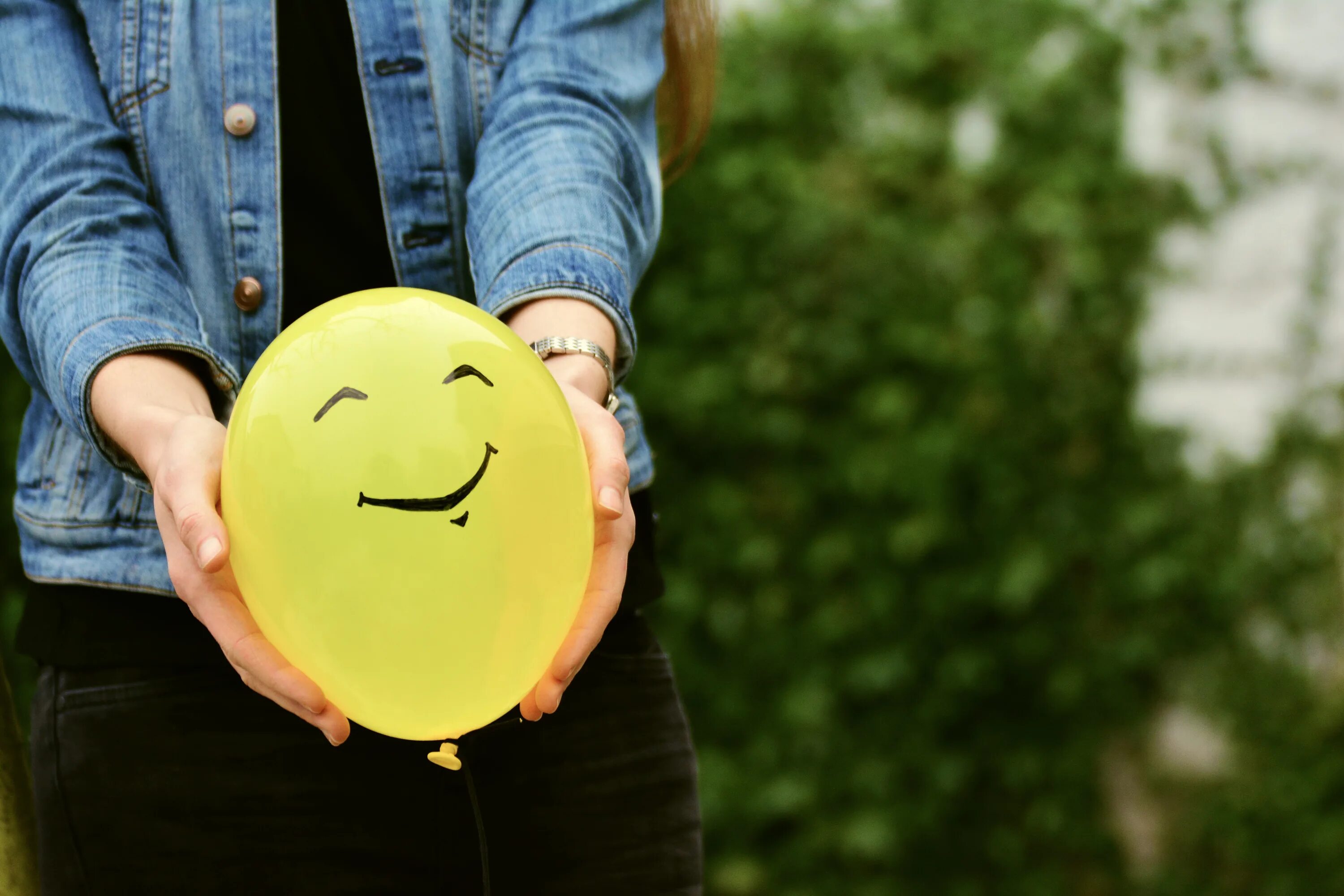 Воздушный шарик в руке. Воздушный шарик с улыбкой. Счастливый человек. Шарик улыбается.