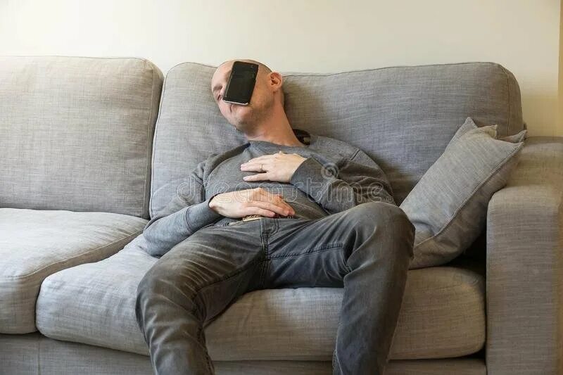 Уставший предложение. Человек на диване с телефоном. Человек уснул на диване.