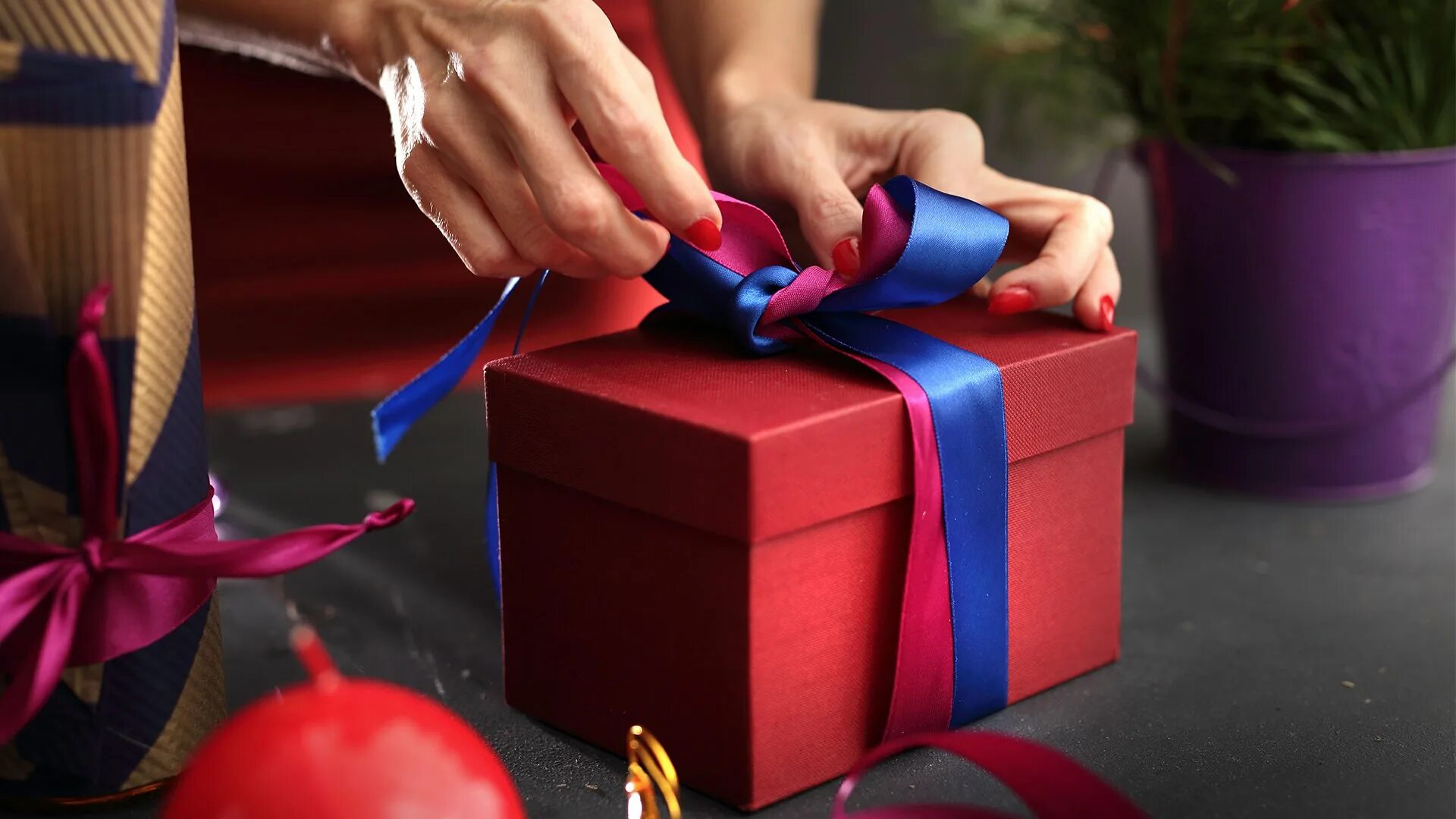 Шагающие подарки. Подарок. Бизнес подарки. Упаковать подарок. Девушка упаковывает подарок.