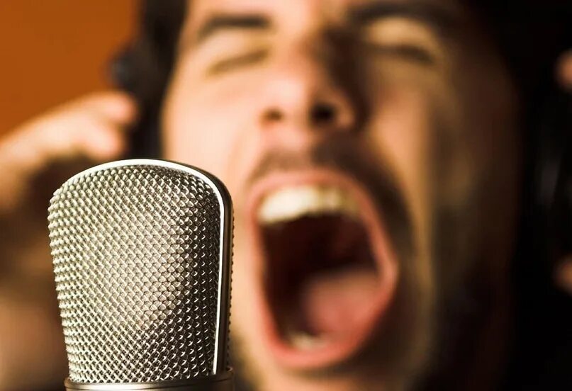 Петь сильным голосом. Кричит в микрофон. Мужчина с микрофоном. Смешной микрофон. Человек кричит в микрофон.
