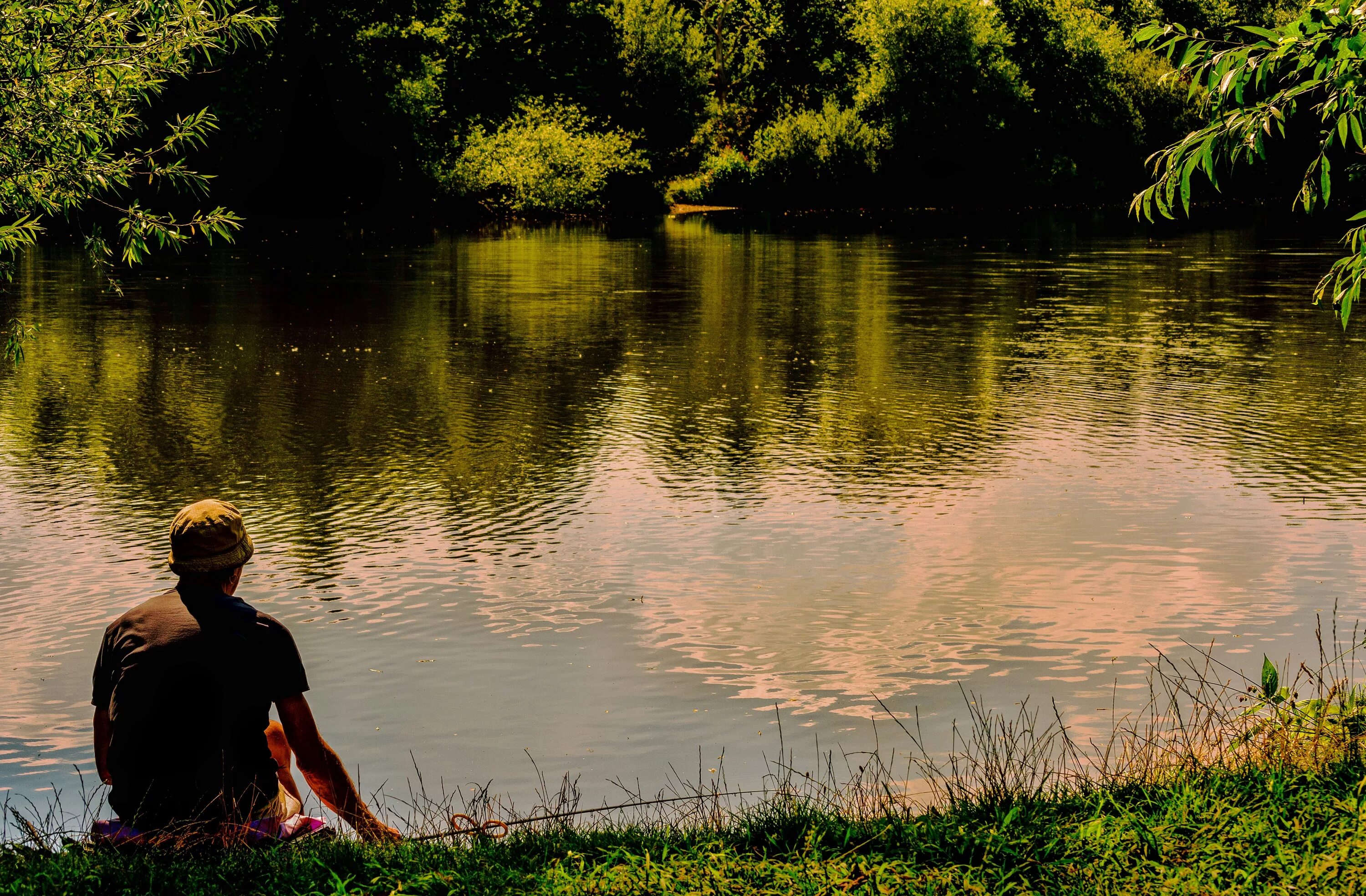 Сидел на озере рыбак. Человек на берегу реки. Парни на озере. Парень на берегу реки. Мужчина сидит на берегу реки.
