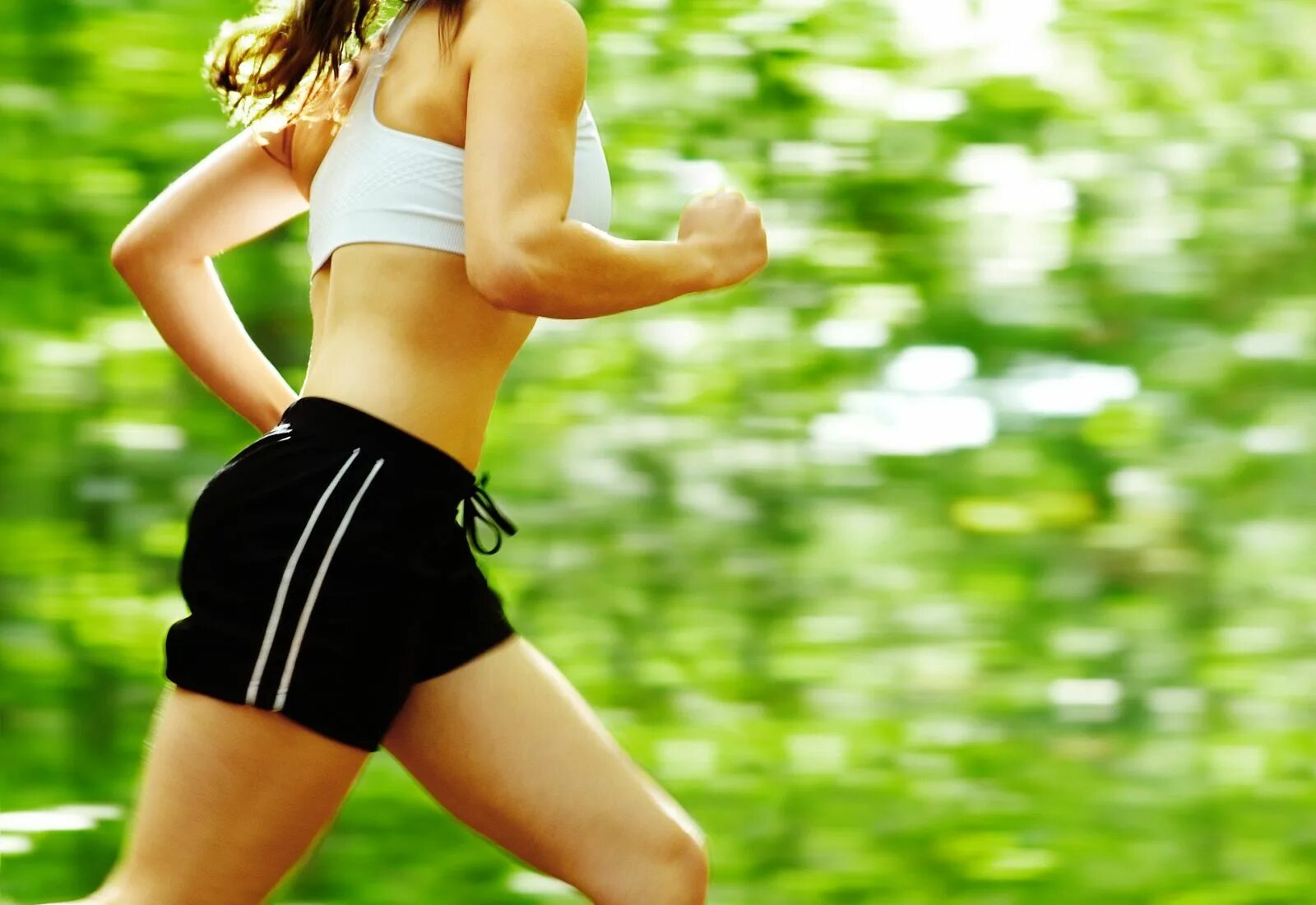 Лучший вид спорта для похудения. Лето бег. Здоровая девушка бежит. Занятие спортом в лесу. Девушка бежит в зеленом.