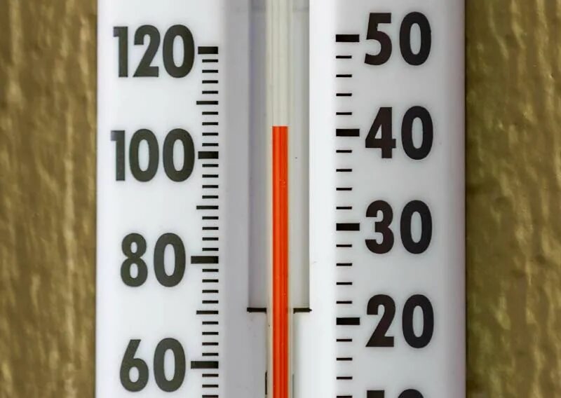 сильная жара. человек в температуре 100 градусов. высокая температура. температурный термометр. температурный градусник.