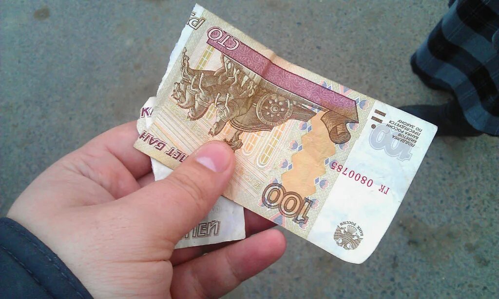 Принимает ли сейчас. СТО рублей в руке. 100 Рублей в руке. Рваная купюра. Порванные денежные купюры.