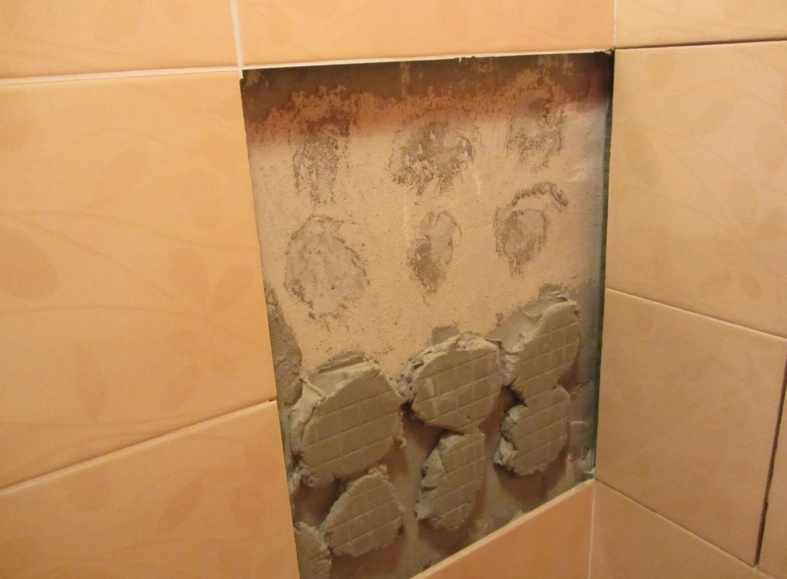 Чем можно закрыть плитку. Плитка отваливается от стены. Отвалилась плитка в ванной. Отслоение плитки от стены. Дефекты плитки.