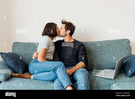 Young couple kissing on sofa hi-res stock photography and images - Alamy