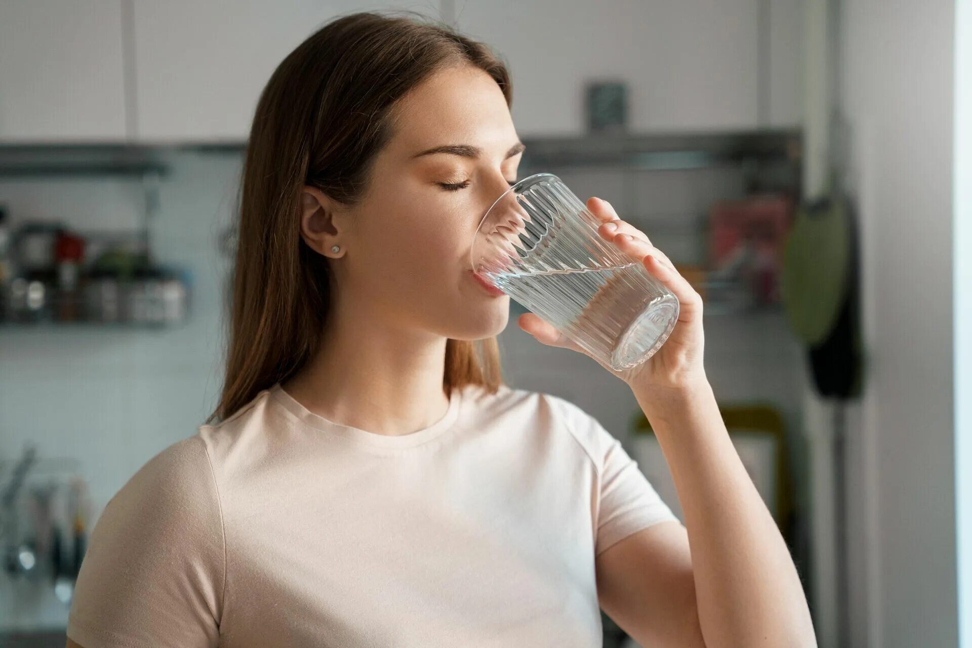 Повышенная жажда. Девушка пьет воду. Девушка со стаканом воды. Вода и человек. Девушка со стаканом воды на кухне.