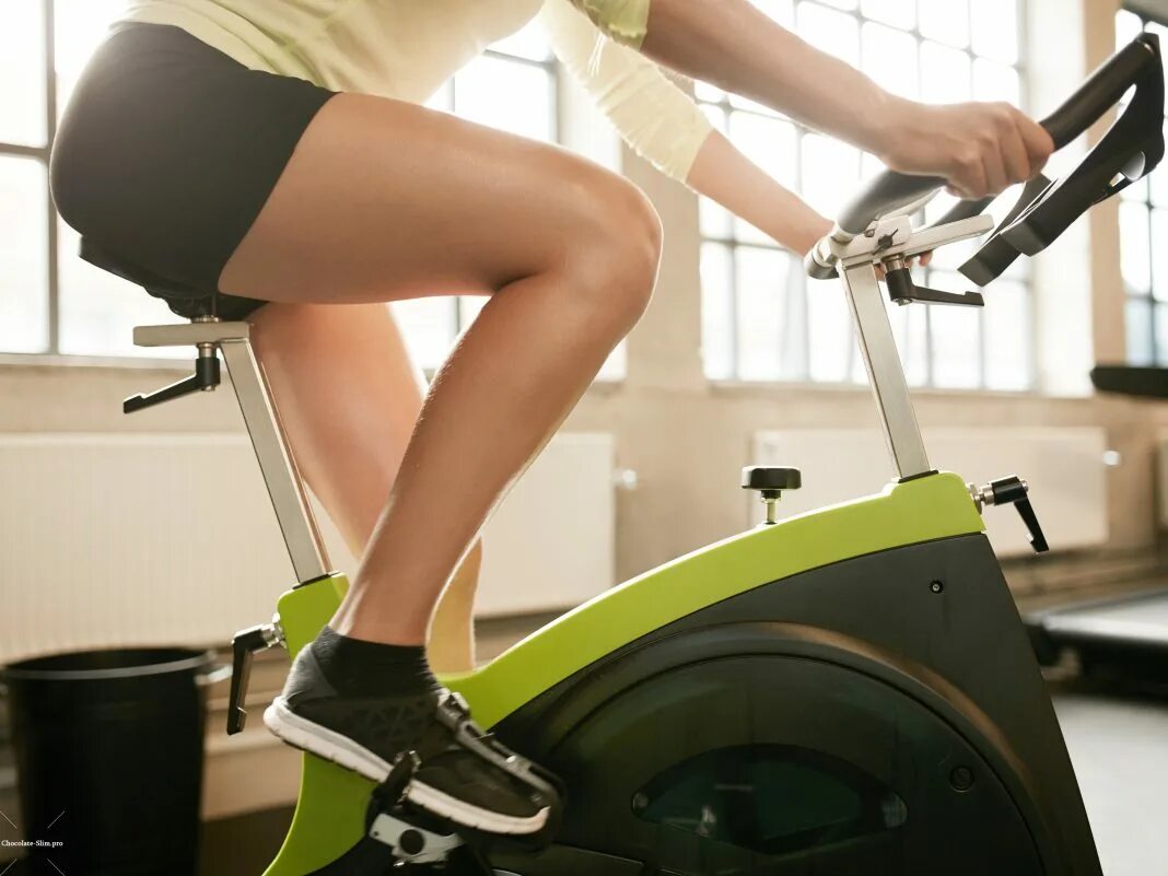 Девушка на велотренажере. Как правильно выбрать велотренажер для дома. Велотренажер. Вертикальный велотренажер hyperset hs-7006. Велотренажер для дома.