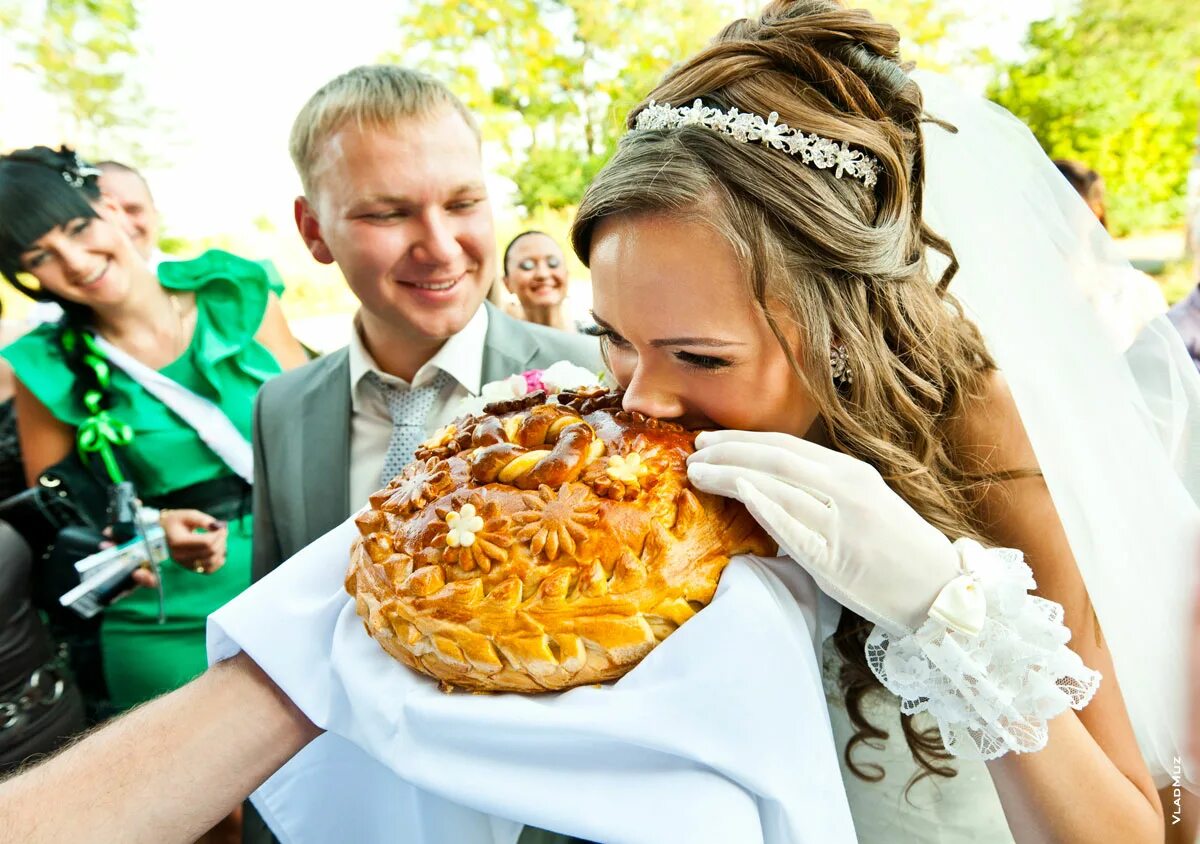 После загса что будет. Каравай на свадьбу. Кусание каравая на свадьбе. Хлеб соль на свадьбе. Молодожены с караваем.