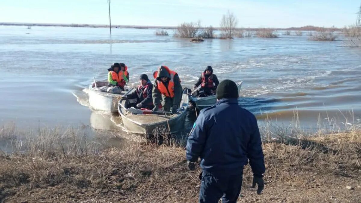 Наводнение в актюбинске. Лодка МЧС. Человек в лодке. Лодки на улице наводнение. Работники на лодке.