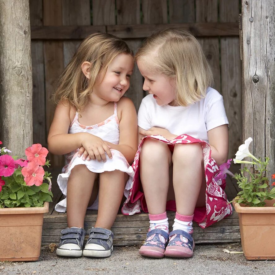 Маленькие девочки двойняшки. Две девочки смеются. Два малыша. Две сестры старшая и младшая. Фотосессия сестер.