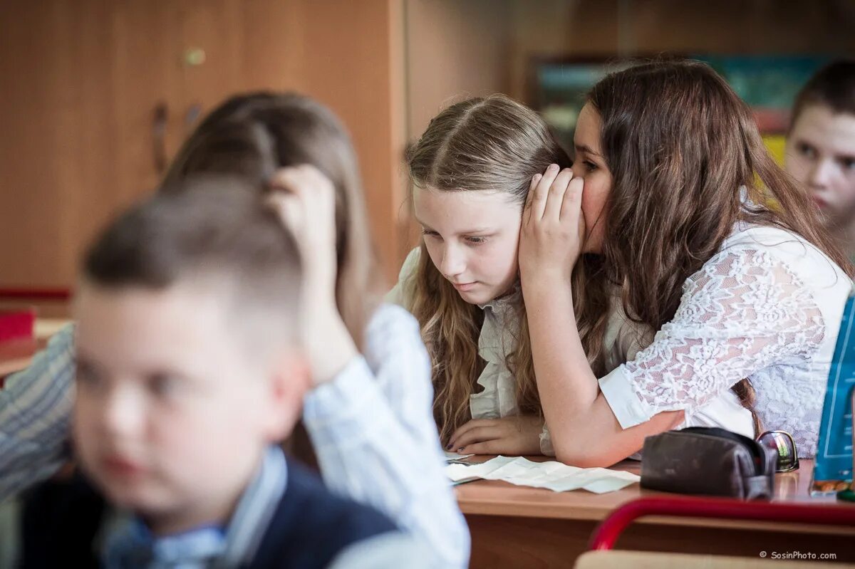 Одноклассники прямо на уроке. Старшеклассники на уроке. Старшеклассники за партой. Школьники на уроке. Репортажная съемка в школе.