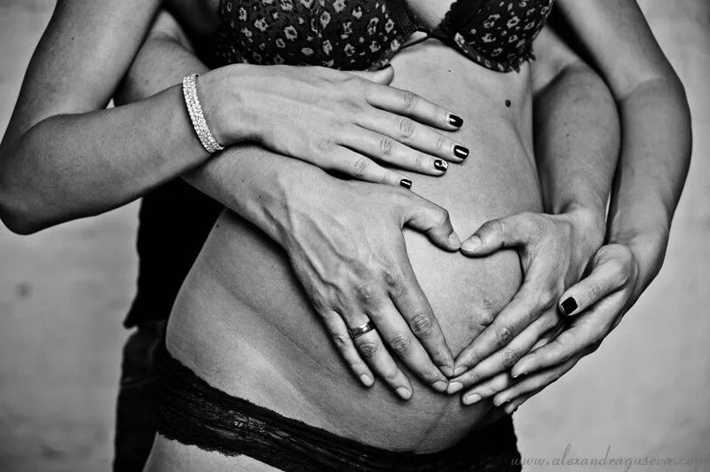 Женщина целует живот мужчине. Целует беременный животик. Целует живот. Мужские руки на женском животике. Парень целует живот беременной.