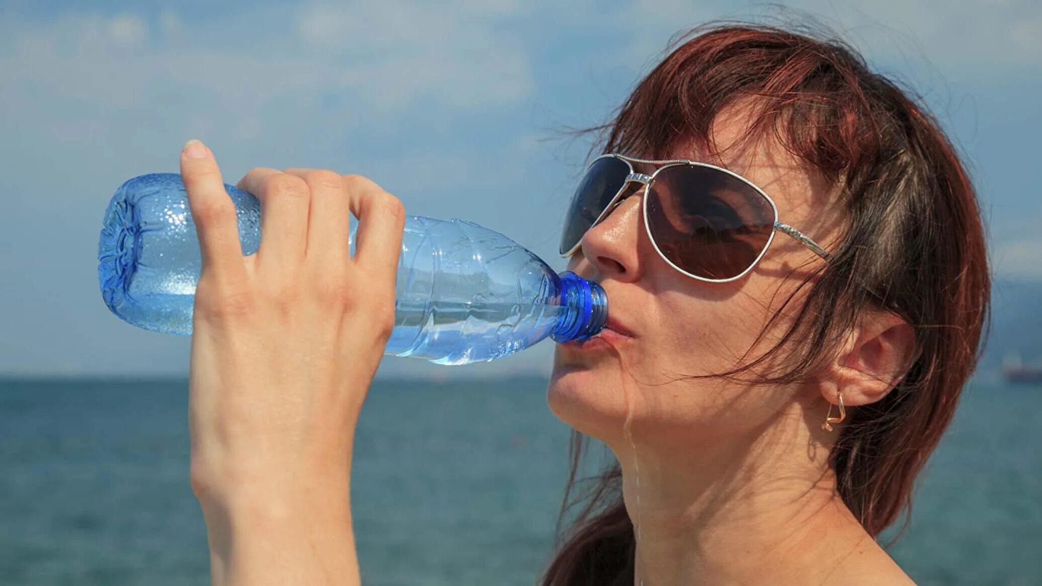 Почему хочется воды. Девушка пьет воду из бутылки. Девушка пьет из бутылки. Девушка из воды. Пить из пластиковой бутылки.