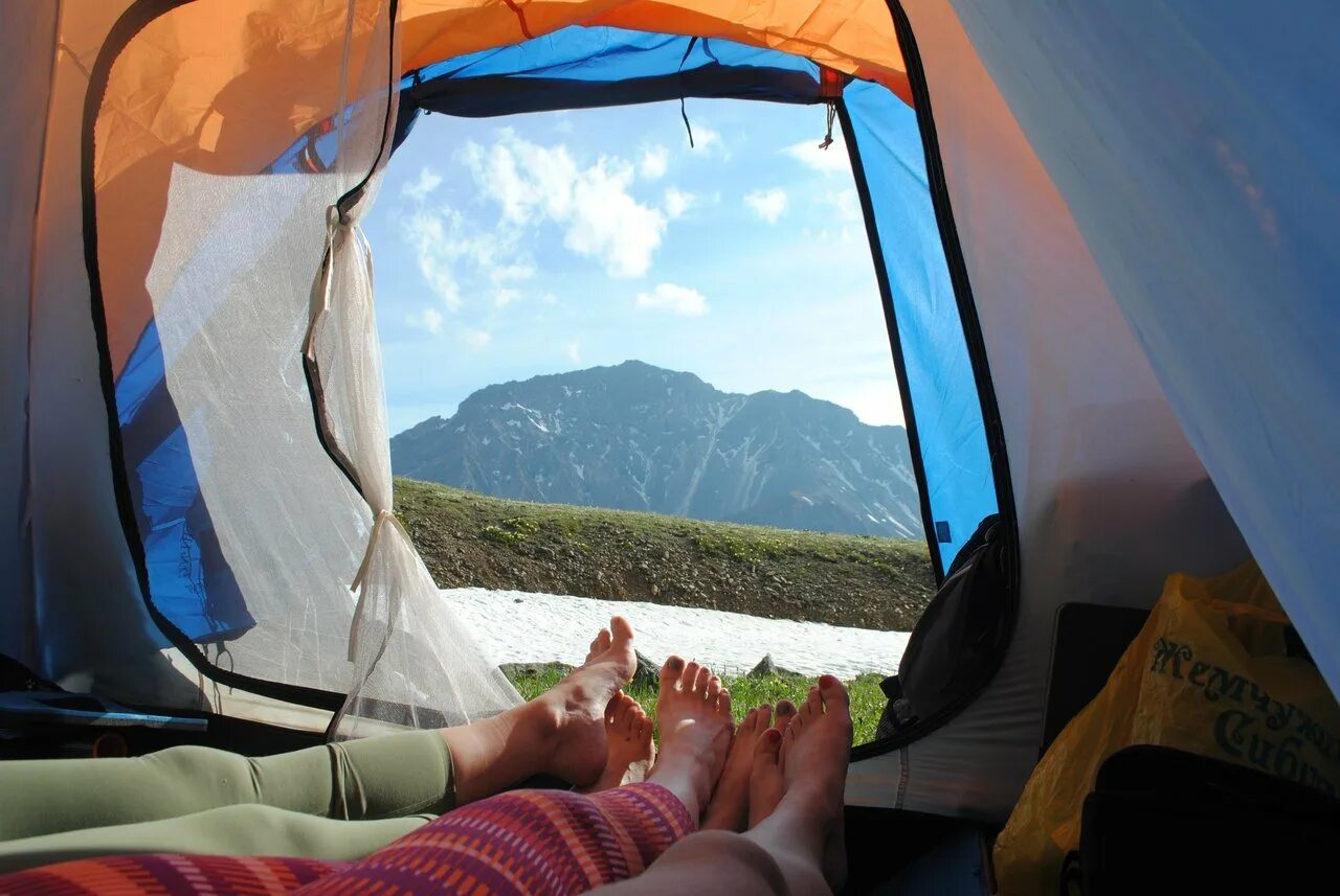 Путешествие путешествовать сверкание победа. Красивый вид из палатки. Ноги из палатки. Вид из палатки на горы. Путешествие с палаткой.