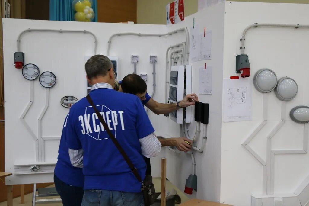Профессиональные компетенции электрика. Компетенция электромонтаж. Worldskills электрики. Кабина электромонтаж. Демонстрационный экзамен у электромонтажников фото.