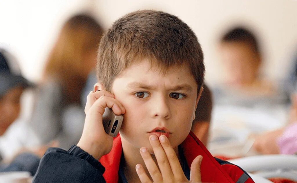 Ученик с телефоном. Ребенок с телефоном. Мальчик с телефоном. Школьник с телефоном. Могут ли дети не разговаривать