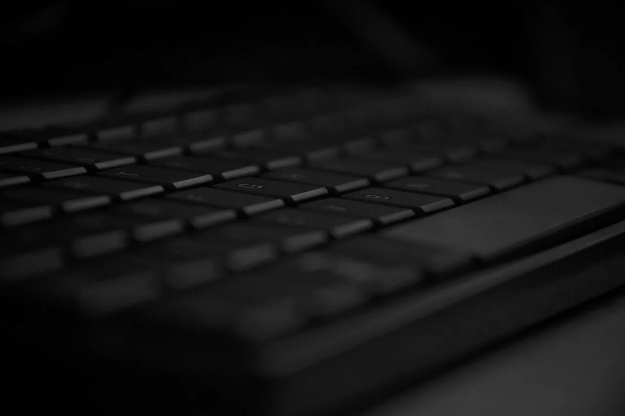 Печатает черный фон. Ноутбук на темном фоне. Компьютер на черном фоне. Клавиатура на темном фоне. Клавиатура ноутбука темный фон.
