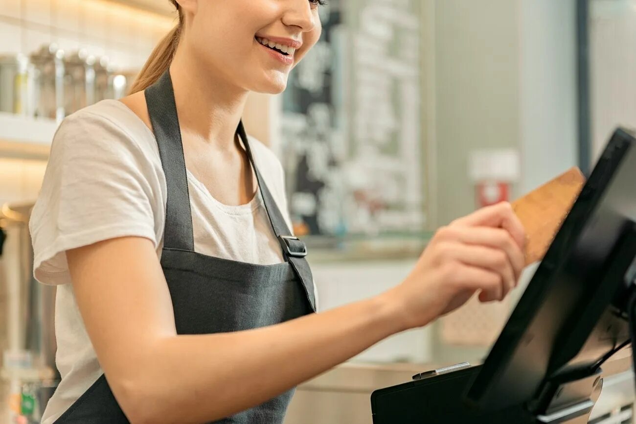 She is a shop assistant. Продавец кассир. Девушка продавец. Девушка за кассой. Девушка кассир.