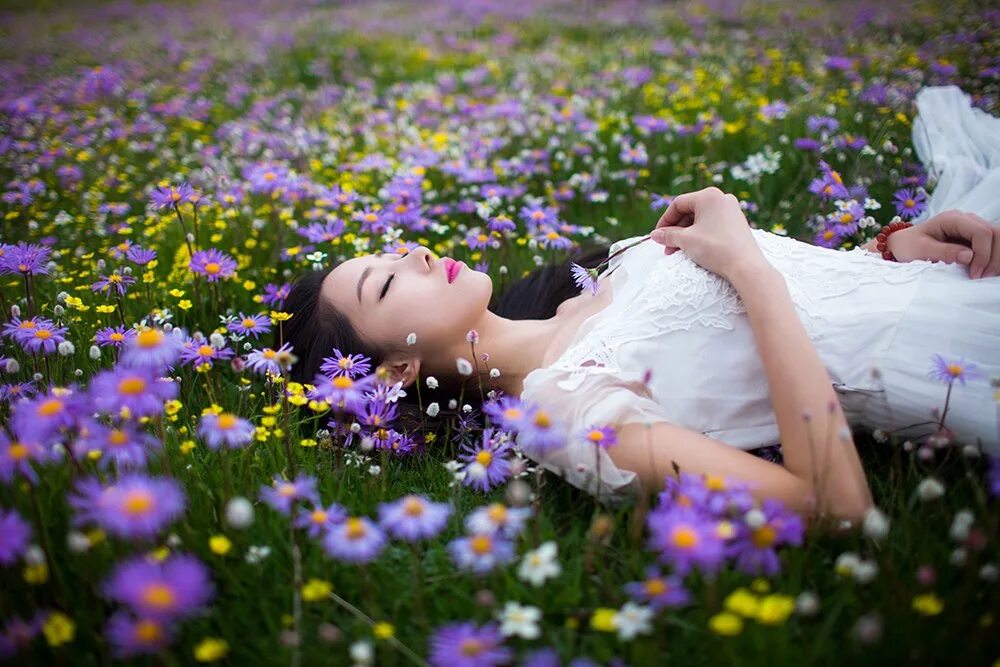 Словно в ярком сне. Девушка лежит в поле цветов. Девушка в цветочном поле. Лежит в цветах. Девушка на Поляне.