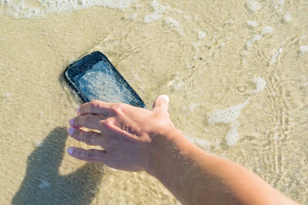 Падающий смартфон на камнях. IPAD В воде. Телефон уронил Стоковая картинка.