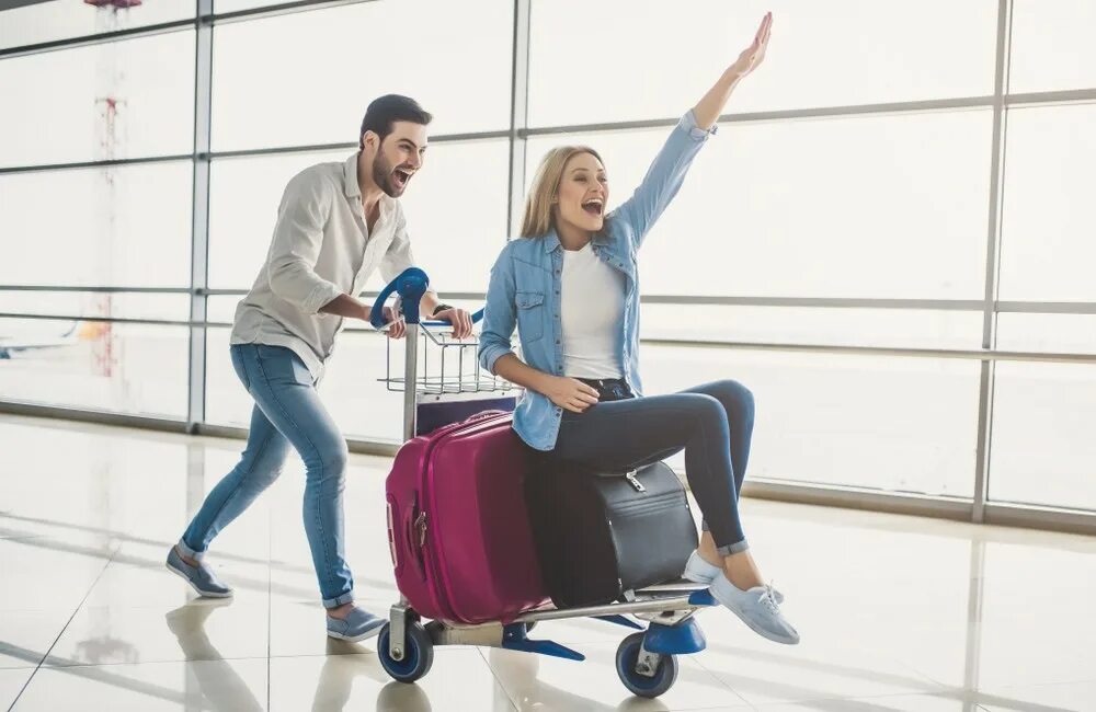 Выбор тура. Мужчина и женщина с чемоданами. Пара в аэропорту с чемоданами. Мужчина и женщина в аэропорту. Мужчина с чемоданом в аэропорту.