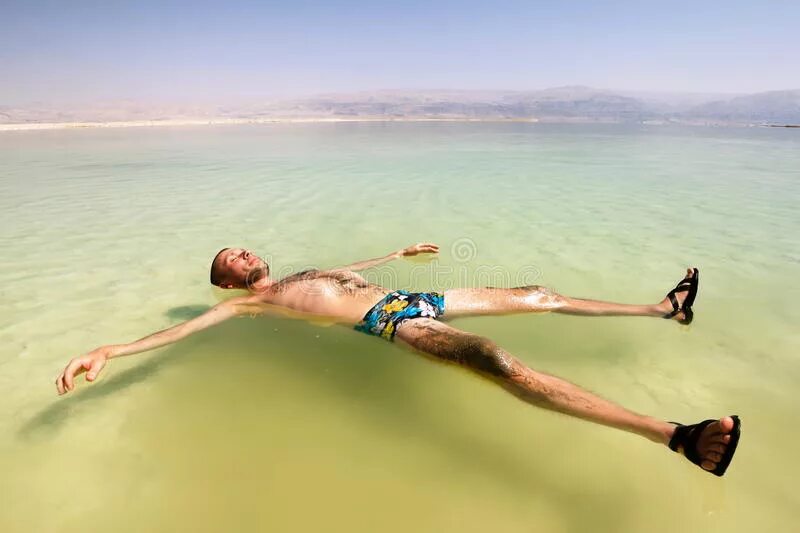 Человек лежит в воде. Мужчина лежит в воде. Лежать на воде. Море человек лежит на воде.