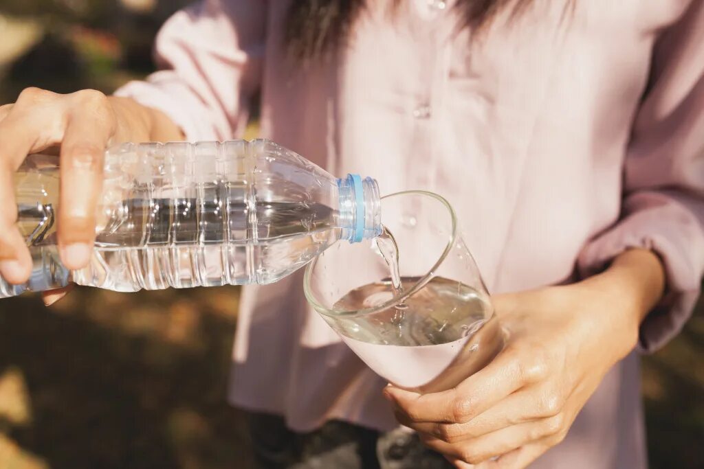 Бутылка для воды с стаканом. Налить воду в бутылку. Бутылка наливает. Воду наливают в стакан. Наполнение водой.