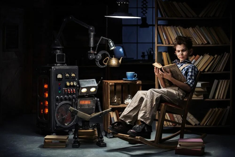 Read books about inventions. Child-robot and inventor-mechanic read books in a workshop late at night. механик читает книгу. krmstudioz and mechanics.