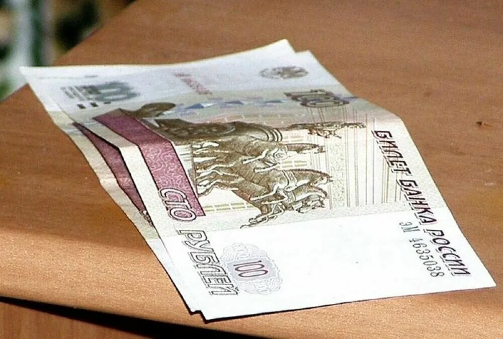 На столе 100 купюр. Деньги на столе. 200 Рублей на столе. 100 Рублей на столе. СТО рублей лежат на столе.