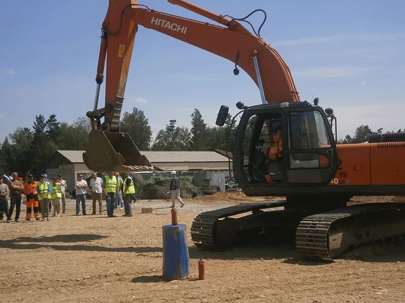 машинист экскаватора в маске тоби. экскаваторщик. показать экскаватор щеплыковал каменного ангела в амурской области.