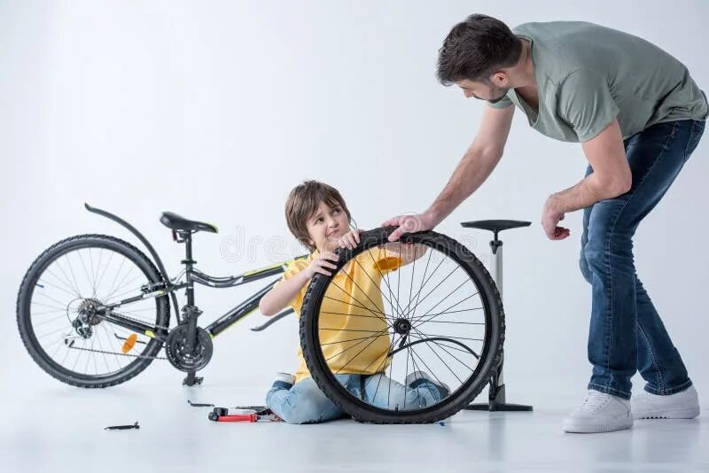 Папа накачивает. Ребенок чинит велосипед. Папа чинит велосипед. Мальчик чинит велосипед. Папа с сыном чинят велосипед.