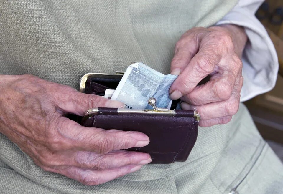 Пенсионерка с кошельком. Пенсионер с кошелкой. Пенсионерка с деньгами. Кошелек в руках пенсионерки.