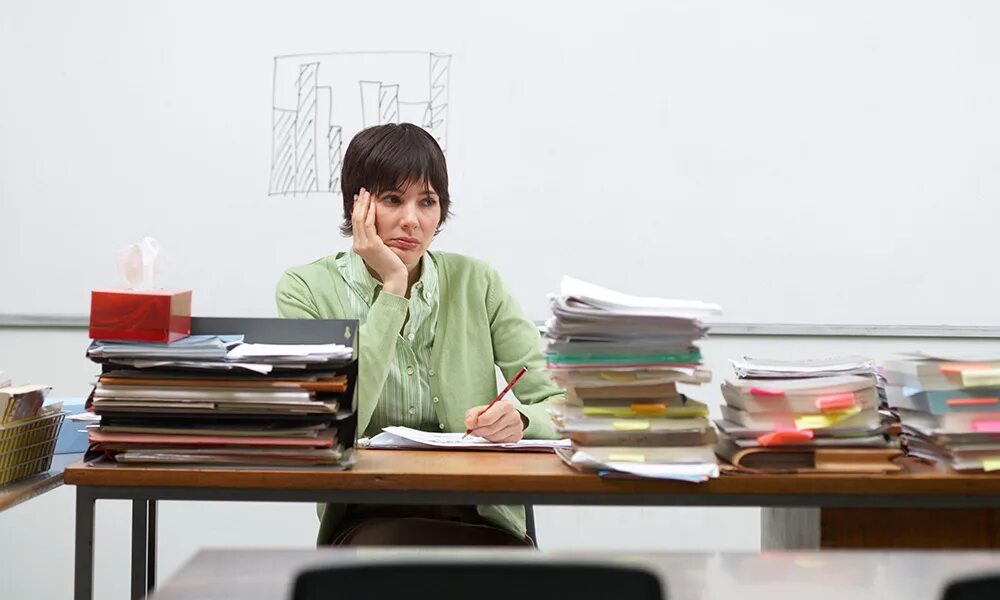 Проверяющая учителей работа. Проверяющая учителей работа. Учитель за столом. Уставший учитель. Учитель проверяет работы.