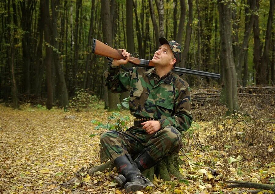 Охота на уставшей. Охотник с ружьем. Мужчина с ружьем на охоте. Солдат на природе. Охотник в лесу.