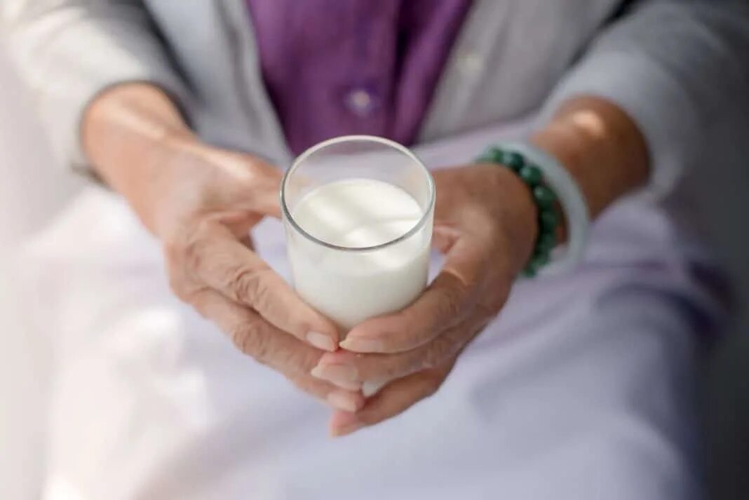 Можно ли с сахарным диабетом пить молоко. Стакан молока в руке. Молоко в стакане. Молоко в руке. Молочные и кисломолочные продукты.